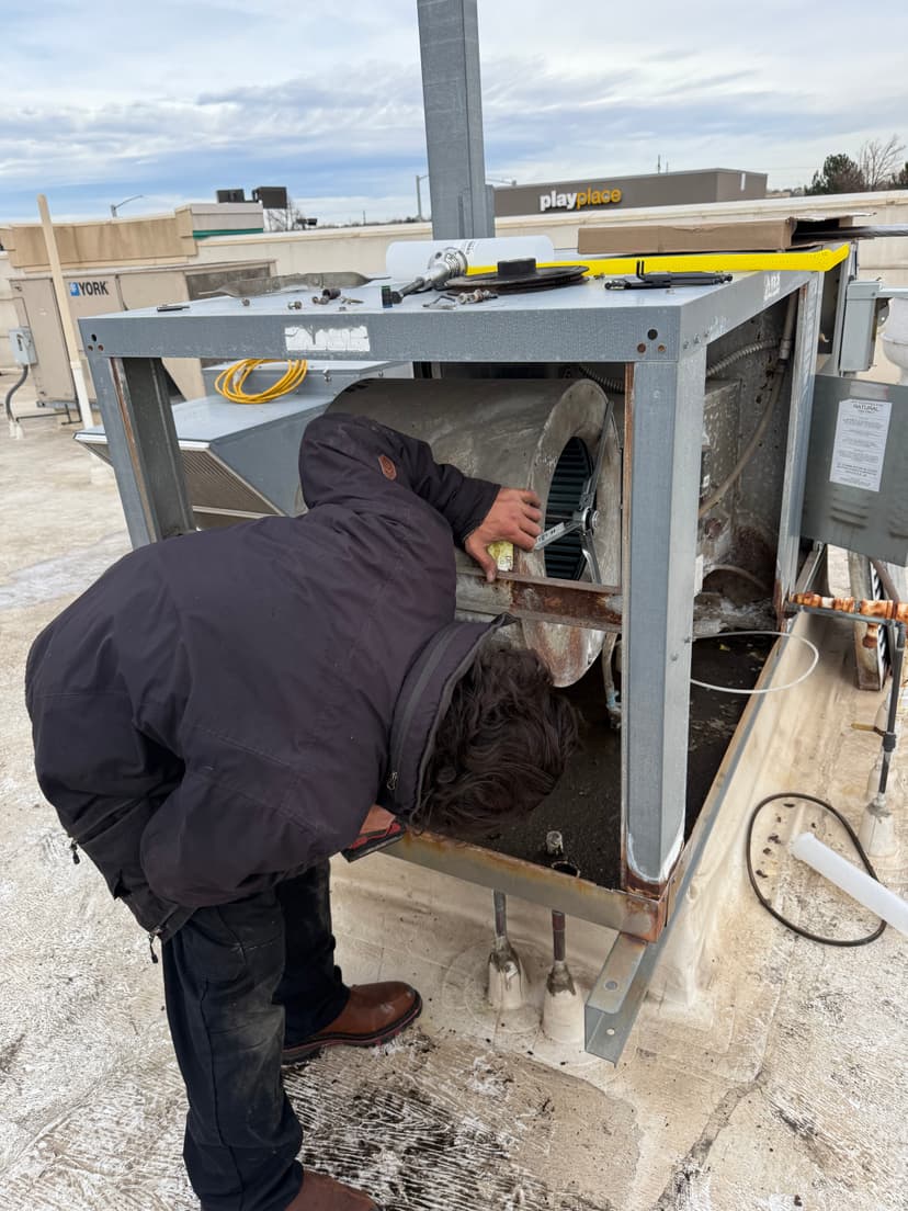 Technician servicing rooftop HVAC unit